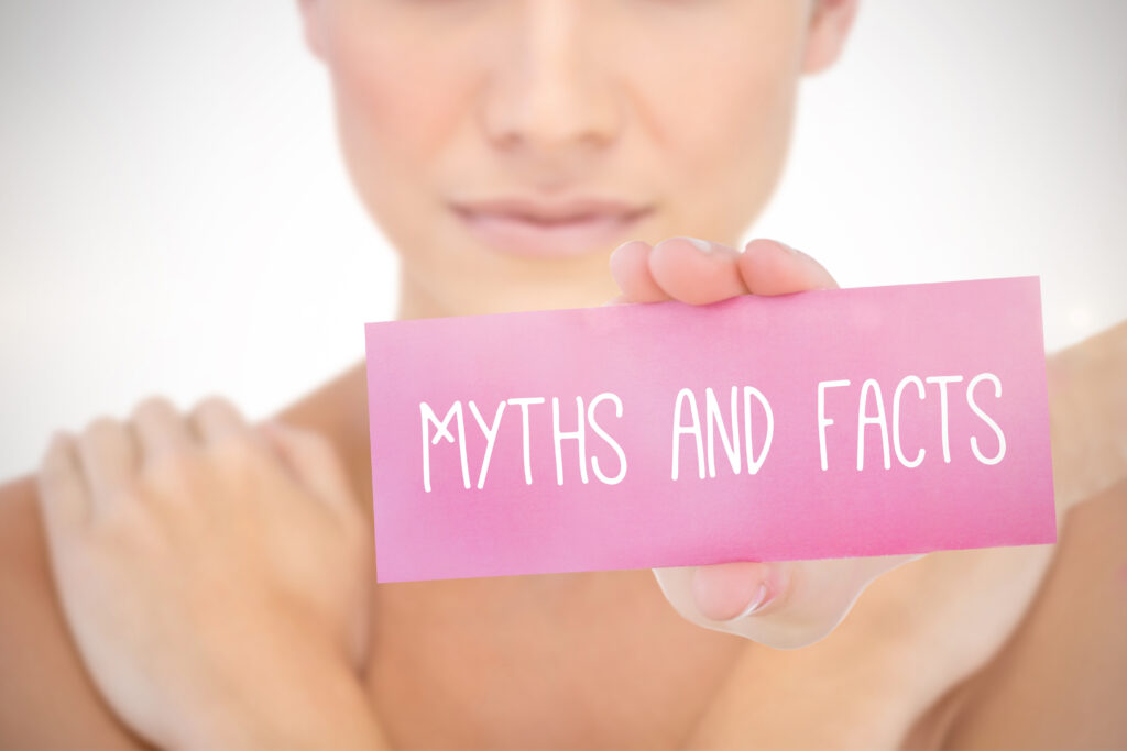 Woman holding a sign saying "myths and facts"