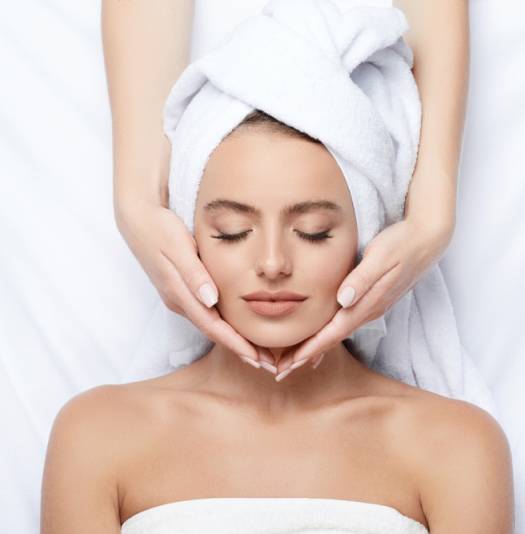 Woman receiving a facial massage treatment.